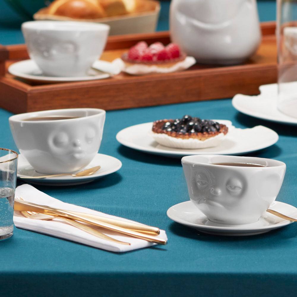 Premium porcelain coffee cup with saucer in white from the porcelain product family of fun dishware by FIFTYEIGHT Products. Offers 6.5 oz capacity and comes with a matching saucer. Dishwasher and microwave safe cup with a 'kissing' facial expression. Shipped in exclusively designed gift box.