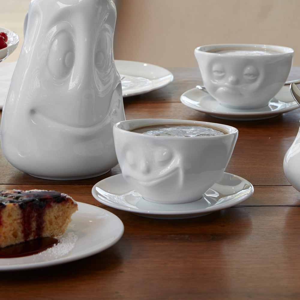 Premium porcelain coffee cup with saucer in white from the porcelain product family of fun dishware by FIFTYEIGHT Products. Offers 6.5 oz capacity and comes with a matching saucer. Dishwasher and microwave safe cup with a 'happy' facial expression. Shipped in exclusively designed gift box.