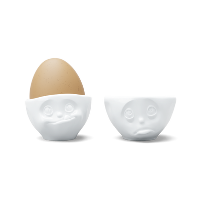 Set of two egg cups in white from the porcelain product family of fun dishware by FIFTYEIGHT Products. Set features two egg cups in white, featuring 'Oh please' and 'tasty' facial expressions. Dishwasher and microwave safe bowls. Shipped in exclusively designed gift box.