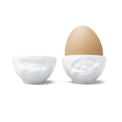 Set of two egg cups in white from the porcelain product family of fun dishware by FIFTYEIGHT Products. Set features two egg cups in white, featuring 'Happy' and 'Hmpff' facial expressions. Dishwasher and microwave safe bowls. Shipped in exclusively designed gift box.