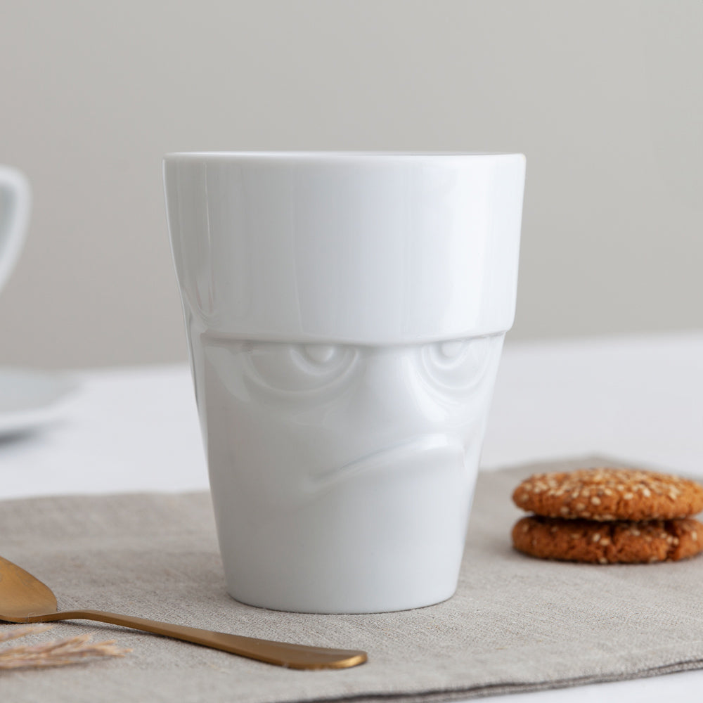 Premium porcelain coffee mug with handle from the porcelain product family of fun dishware by FIFTYEIGHT Products. Offers 11 oz capacity for serving coffee, tea, latte, matcha, soup and more. Dishwasher and microwave safe cup with a 'grumpy' facial expression. Shipped in exclusively designed gift box.