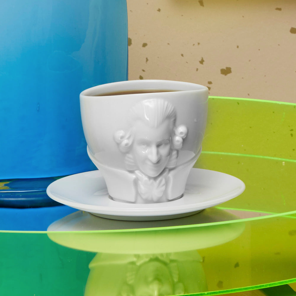 Premium porcelain coffee cup with saucer in white with sculpted Wolfgang Amadeus Mozart face. Dishwasher and microwave safe cup at 8.7 oz capacity. From the TALENT product family of cups dedicated to creative geniuses by FIFTYEIGHT Products. Made in Germany according to environmental standards.