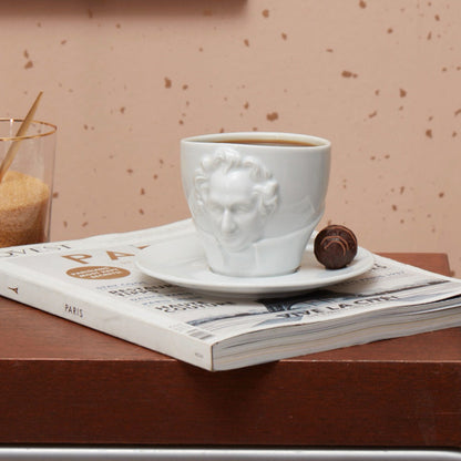Premium porcelain coffee cup with saucer in white with sculpted Johann Wolfgang von Goethe face. Dishwasher and microwave safe cup at 8.7 oz capacity. From the TALENT product family of cups dedicated to creative geniuses by FIFTYEIGHT Products. Made in Germany according to environmental standards.